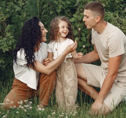 A joyful family enjoying time together in a lush green meadow, capturing love and bonding.