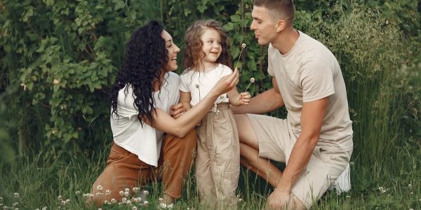 A joyful family enjoying time together in a lush green meadow, capturing love and bonding.